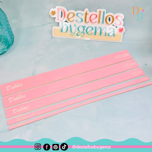 Regla metálica con medidas en pulgadas y centímetros sobre mesa de trabajo.
